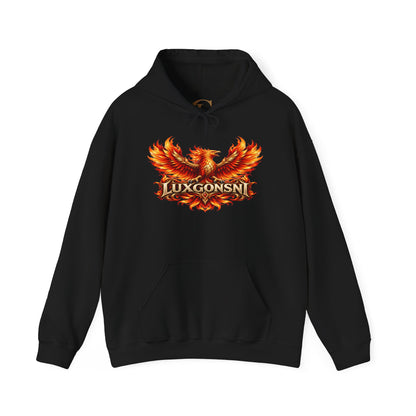 Man wearing a black LUXGONSNI pullover hoodie with a red, orange, and gold phoenix graphic across the chest, outdoors at sunset.